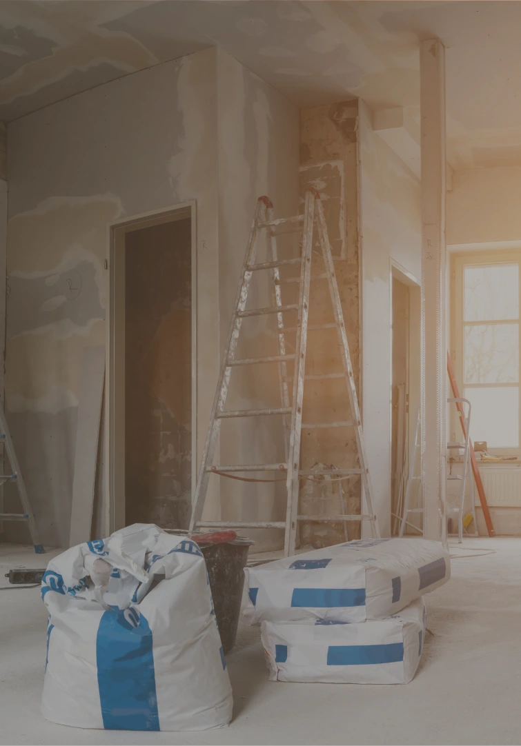 An image of an uncompleted building with ladder and bags of cement in the background